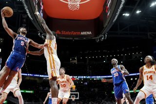 Clint Capela (au centre) tente de s'interposer face à Quentin Grimes. KEYSTONE/AP/Mike Stewart